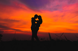 a person standing in front of a sunset jigsaw puzzle