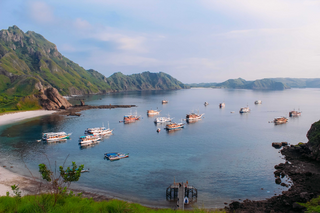 a small boat in a body of water with a mountain in the background jigsaw puzzle