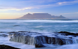 a large waterfall over a body of water with Table Mountain in the background jigsaw puzzle