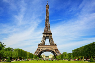 a large tall tower with a clock at the top of a field with Eiffel Tower in the background jigsaw puzzle