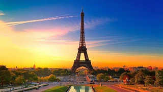 a large clock tower towering over Eiffel Tower at sunset jigsaw puzzle
