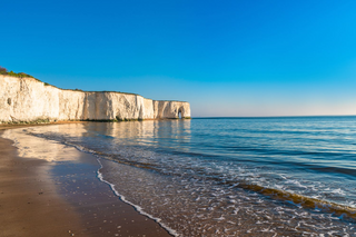 a sandy beach next to the ocean jigsaw puzzle