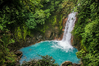 a large waterfall over a body of water with Celeste River in the background jigsaw puzzle